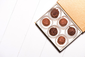 A lot of variety chocolates in box on white wooden background