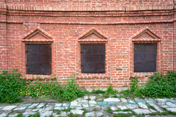 Old red brick building with black metal doors on windows