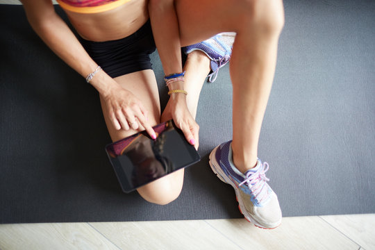 Ragazza con abbigliamento sportivo cerca esercizi su tablet a casa