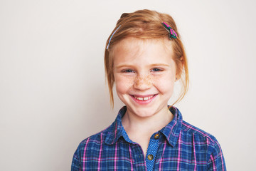 Portrait of happy redhead little girl smiling.