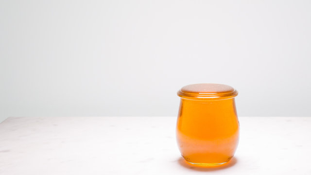 Perfectly full jar of honey with copy space to the left.  Life is full and sweet!