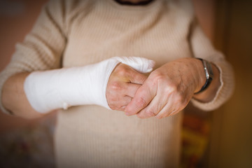 Woman with hand in gypsum. Selective focus.