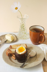 Breakfast, boiled egg, croutons, butter and tea