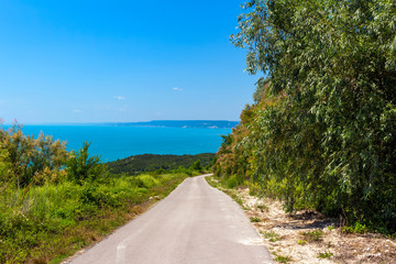 Sea view from altitude on the hill and road that descend towards the sea