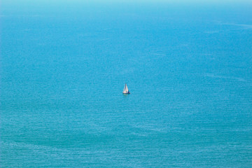 Obraz premium Sea view from altitude, sailing boat in azure water at the sunny summer day