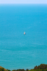 Naklejka premium Sea view from altitude, sailing boat in azure water at the sunny summer day