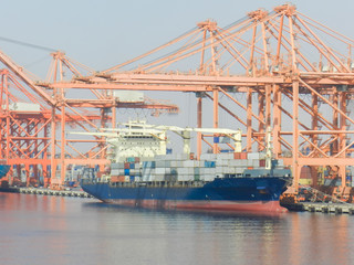 Fototapeta premium Logistic concept,Container cargo ship docking port for loading containers from the ship. For delivery to various destinations.