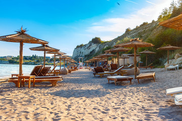 Black sea coast, sand beach with sunbeds and straw umbrellas, summer sea rest concept © O.Farion