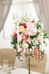 Beautiful decoration on wedding table with roses in bouquet