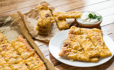 Homemade Cheesy Breadsticks from yeast dough with Spices (garlic, dill, sesame)