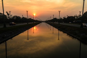 Sunset over a highway Utthayan Road and reflection on the river.