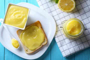Composition with fresh toast and delicious lemon curd on wooden table