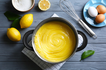 Composition with delicious lemon curd and ingredients on wooden table