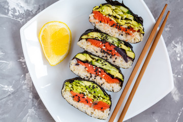 Healthy Japanese onigirazu with fish, brown rice and vegetables.