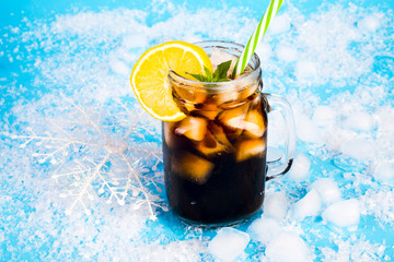 summer drink with ice and lemon on blue background