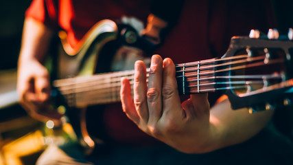 Fototapeta premium Behind scene. Guitarist practice playing guitar in messy music studio