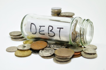 Debt lable in a glass jar with coins spilling out