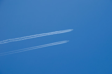 Two planes flying in parallel, leaving behind a white trail.