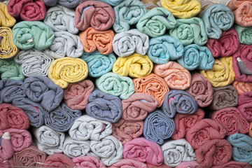 the Scarves, folded into rollers, lie one on one. Picturesque background