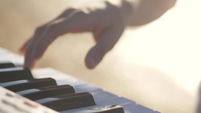 hands of men play on the synth. Man hands playing a MIDI controller keyboard synthesizer. Close up slowmotion video full hd.