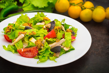 Fresh salad with chicken, mushrooms, lettuce, tomato and mustard dip. Dark stone background. Top view. Close-up