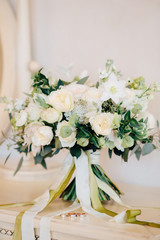 beautiful wedding bouquet with white, red and purple flowers standing on a white chair
