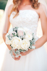 Naklejka premium the bride holds a bouquet with white, red, yellow, purple and white flowers