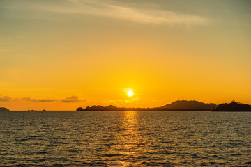 Naklejka na ściany i meble Beautiful seascape sunset view from sea with island on horizon