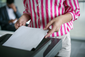 Close up of  business woman uses copier. Businesswoman using photocopier in office.