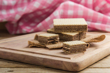 Fototapeta na wymiar Chocolate wafers on chopping wood.