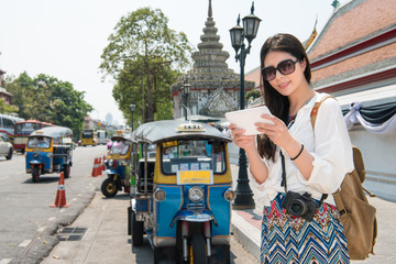 Tablet woman walking near Wat Pho in bangkok.