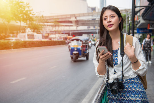Woman walking in bangkok city using phone app