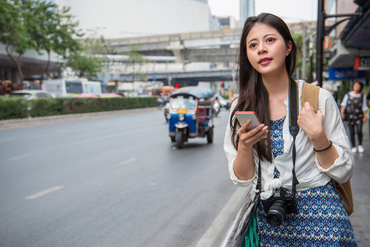 Woman walking in bangkok city using phone
