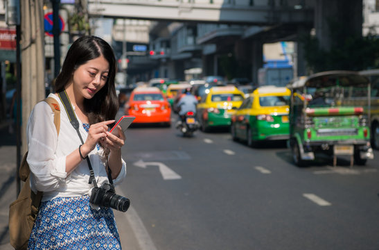 Asian backpacker woman using mobile phone app