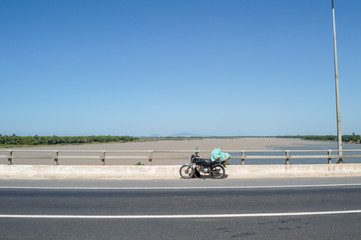 Merging Rivers and Motorcycle on a Bridge near Hoi An, Vietnam