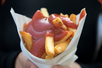 bag of salted French fries with ketchup