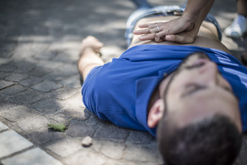 ragazza esegue rianimazione cpr con massaggio cardiaco a giovane svenuto dopo arresto cardiaco