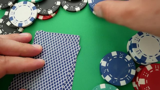 Poker Player Makes a Bet On The Table With Poker Chips. Cards On Table In Casino