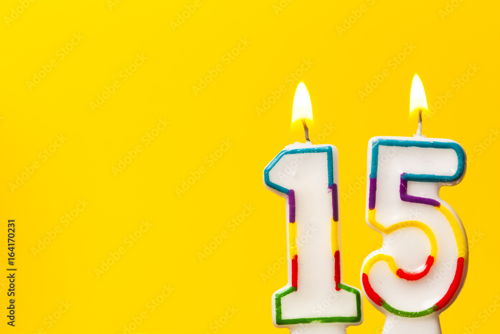 Wall mural number 15 birthday celebration candle against a bright yellow background