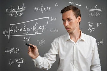 Man scientist or student working with various high school maths and science formulas.