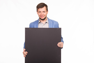 Young happy man portrait of a confident businessman showing presentation, pointing paper placard gray background. Ideal for banners, registration forms, presentation, landings, presenting concept.