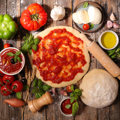 cooking pizza with tomato sauce,mozzarella and basil