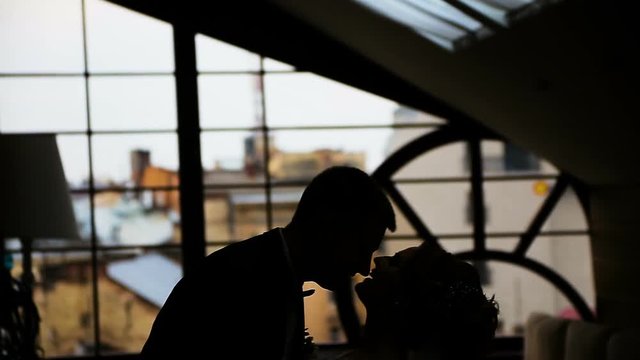 Couple is Kissing and Hugging in the Darkness Silhouette in Love near the Window