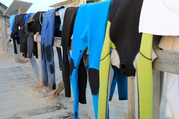 Neoprene costumes hanging on the wooden path to Tarifa beach, Spain