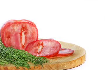 Fresh tomato with dill and on a wooden cutting board on a white background