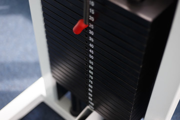 Black iron heavy plates stacked of weight machine in fitness gym. Sports simulator plates. Selective focus