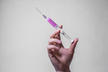 close up women hold pink syringe with drug for patient