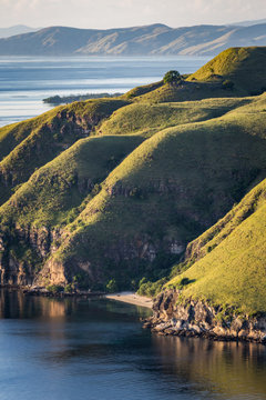 Beach is surrounding by high hills with island background.