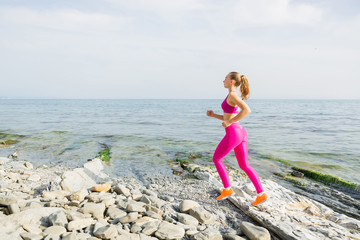 Fitness woman running on beach. Young woman jogging workout, wellness concept.