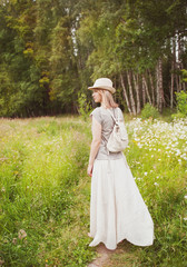 Beautiful woman in long dress on the summer meadow